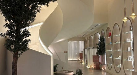 تصميم داخلي فاخر في Myomi Spa، الرياض، يشمل درج حلزوني وأضواء دافئة.