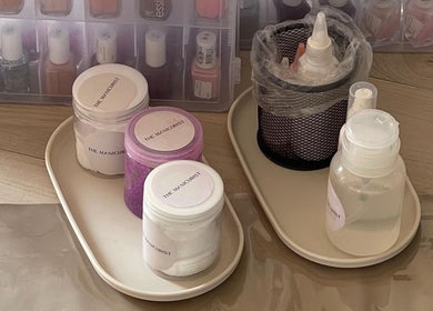 Nail care supplies at The Manicurist, Dubai, Abu Dhabi, AE showcase organized bottles and jars.