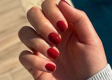 Close-up of a hand with red nail polish from The Manicurist, Dubai, Abu Dhabi, AE.