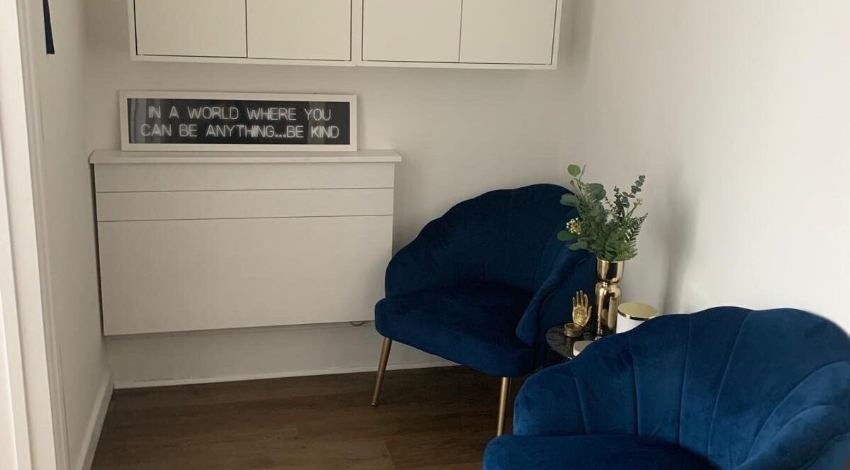 Elegant waiting area at My Face Atelier, High Wycombe, England, GB with blue chairs and decorative plants.