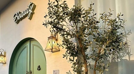 Zan Beauty | زان بيوتي صالون نسائي entrance with green door and olive tree, Riyadh, Riyadh Province, SA.