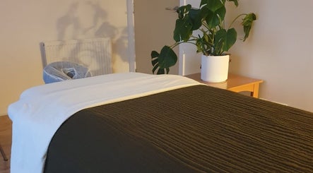 Cozy massage room at The Zen Hen, Glasgow, Scotland, GB, with a lush plant accent.