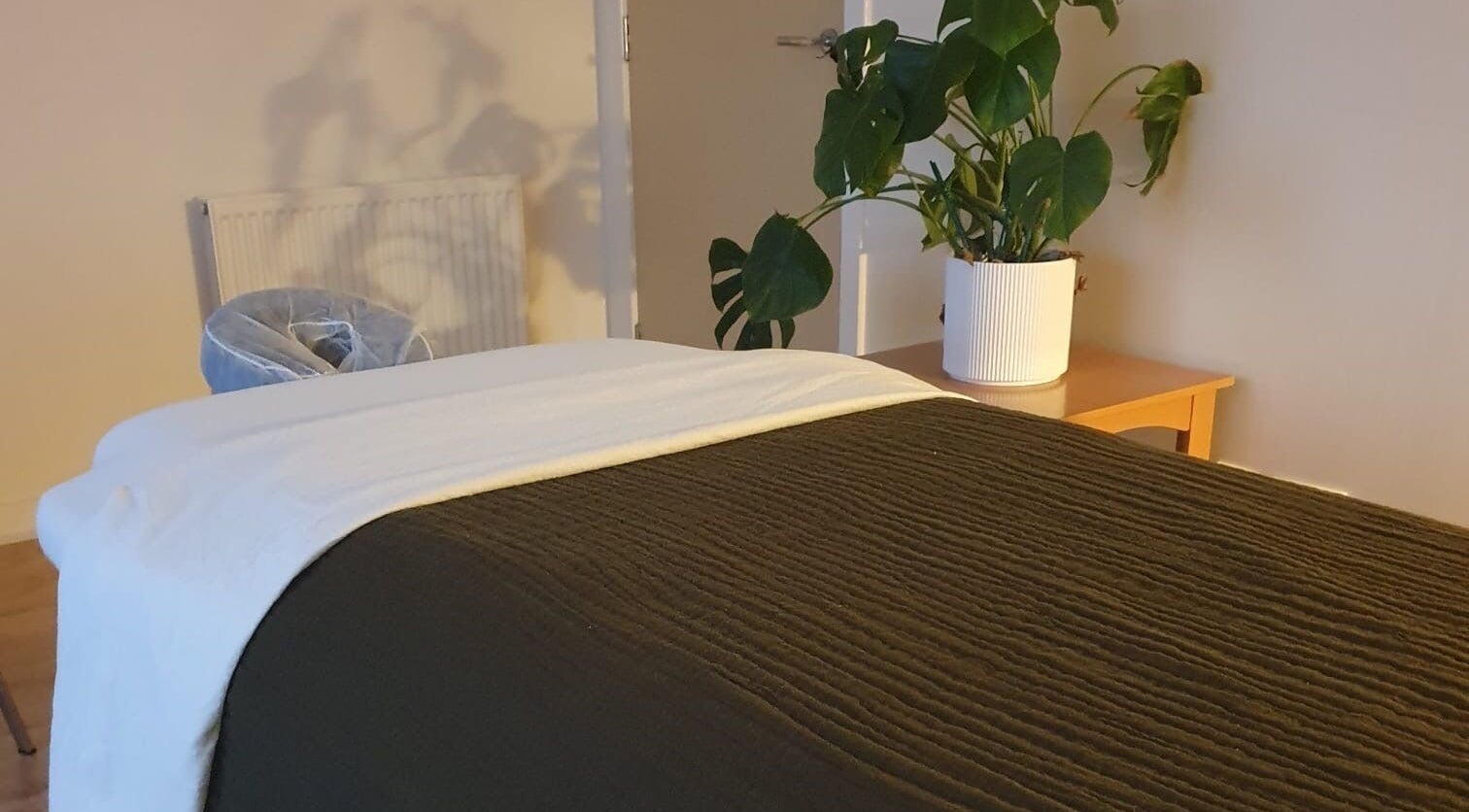 Cozy massage room at The Zen Hen, Glasgow, Scotland, GB, with a lush plant accent.