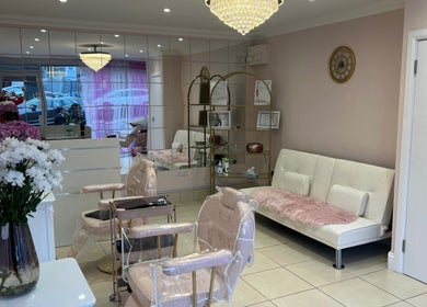 Elegant interior of Rose Gold Hair & Beauty in Hounslow, England, showcasing plush seating and a chandelier.