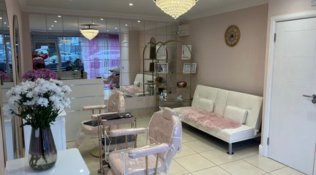 Elegant interior of Rose Gold Hair & Beauty in Hounslow, England, showcasing plush seating and a chandelier.
