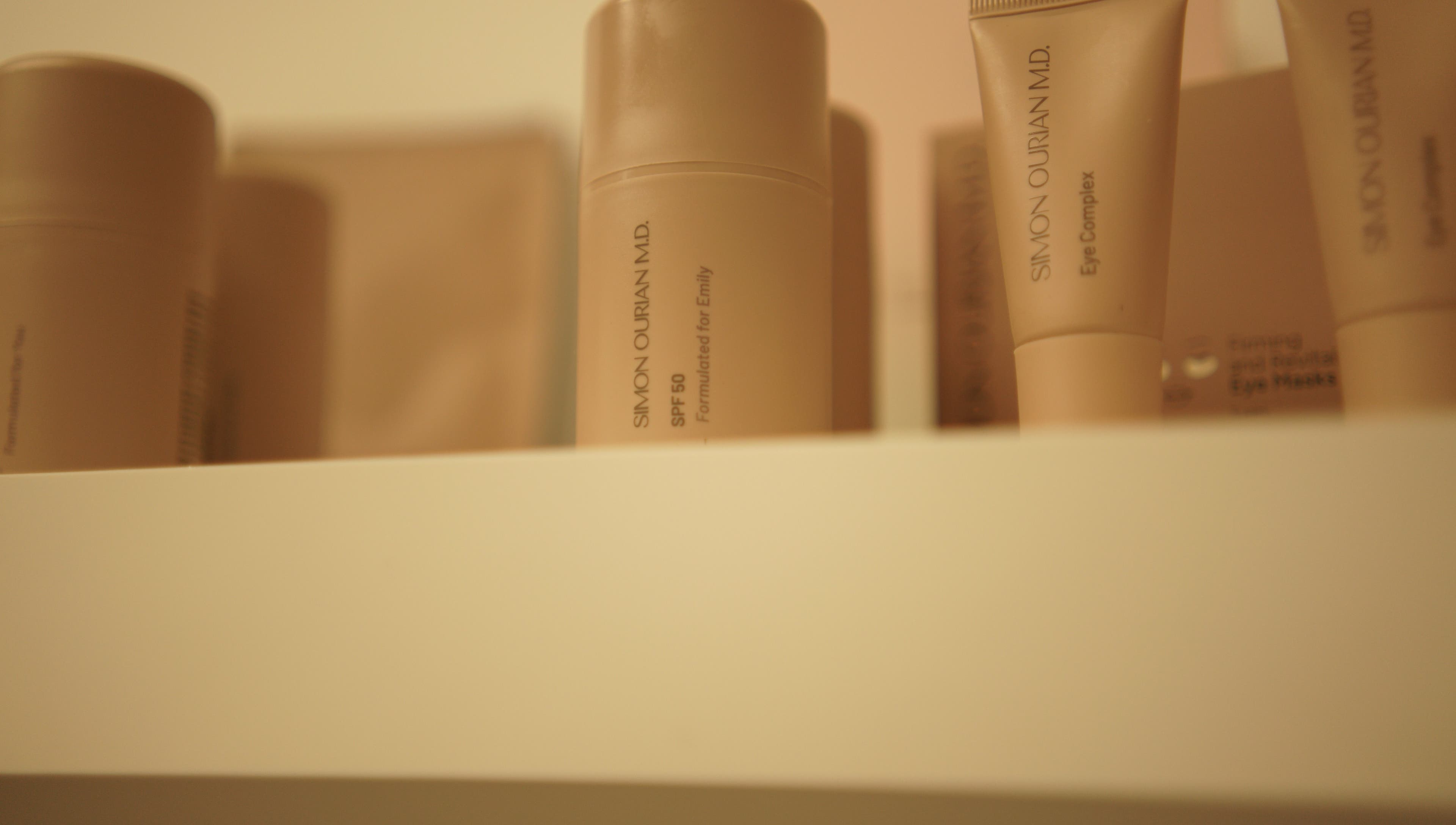 Verzorgingsproducten op plank bij Glow By Ems, Arkel, Zuid-Holland, NL voor ultieme schoonheidsverzorging.