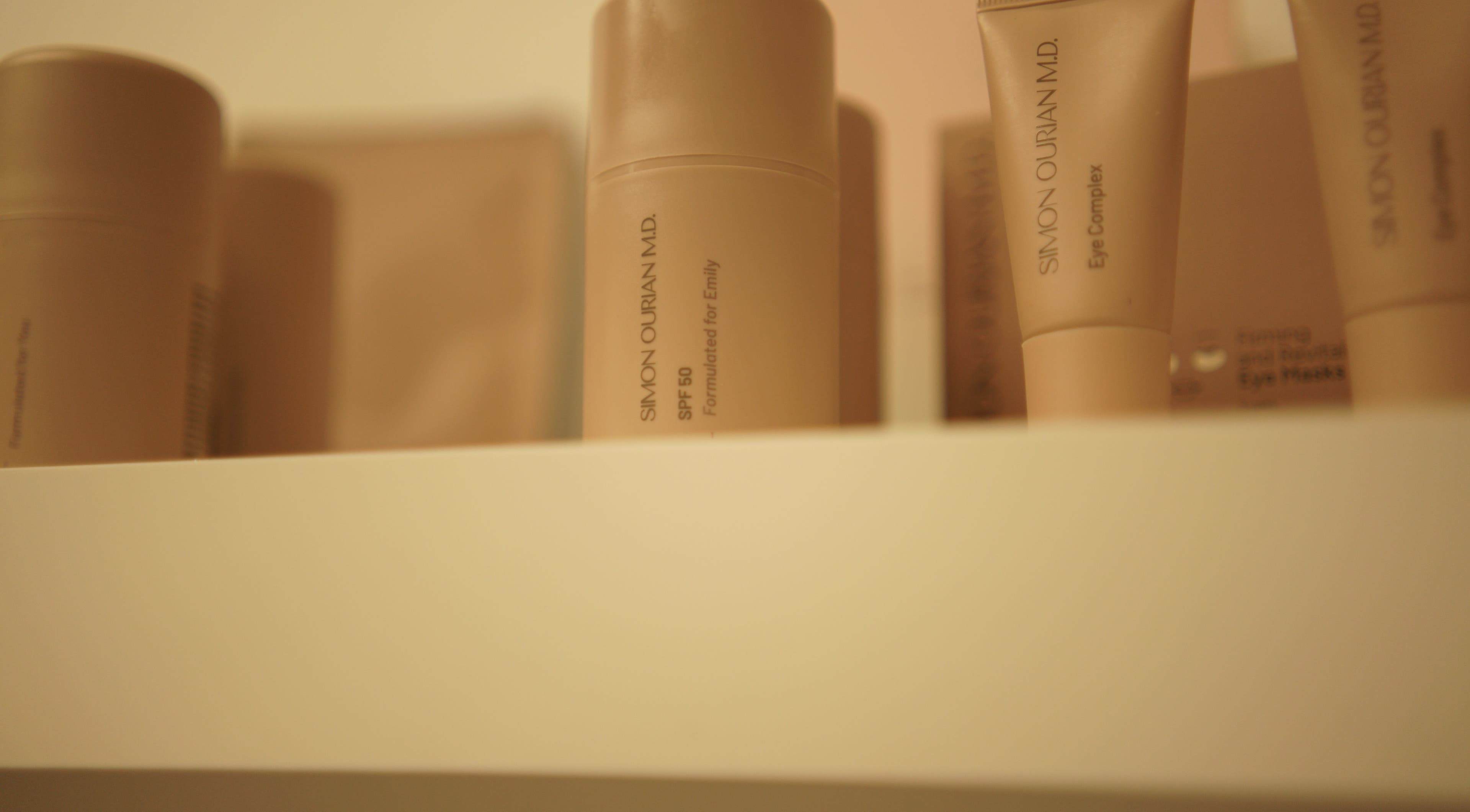 Verzorgingsproducten op plank bij Glow By Ems, Arkel, Zuid-Holland, NL voor ultieme schoonheidsverzorging.