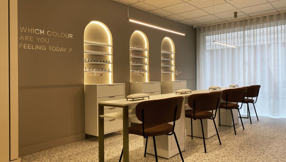 Interior do lounge NAILISH em Porto, PT, com poltronas elegantes e luz suave.