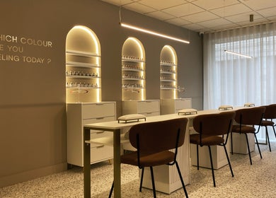 Interior do lounge NAILISH em Porto, PT, com poltronas elegantes e luz suave.