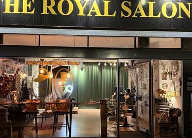 Indgangen til The Royal Salon, Søborg, DK, oplyst om aftenen med stilfuld interiør.