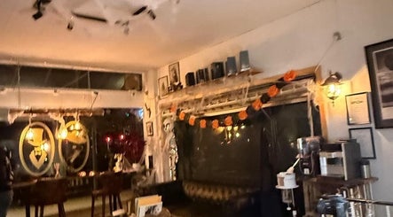 Hyggelig Halloween-indretning på The Royal Salon, Søborg, DK, med varme lys og festlige dekorationer.