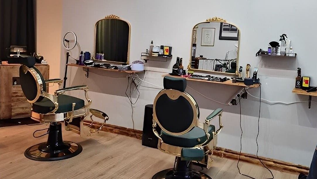 Eksklusivt interiør hos The Royal Salon i Søborg, DK med elegante frisørstole og smukt oplyste spejle.