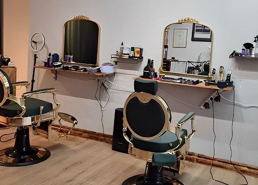 Eksklusivt interiør hos The Royal Salon i Søborg, DK med elegante frisørstole og smukt oplyste spejle.