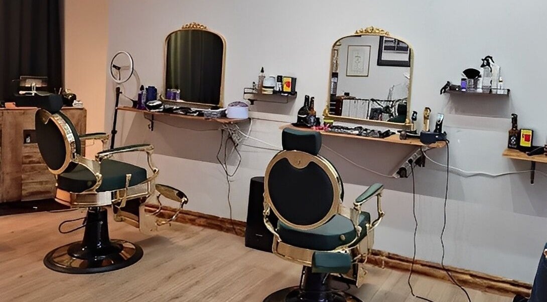 Eksklusivt interiør hos The Royal Salon i Søborg, DK med elegante frisørstole og smukt oplyste spejle.