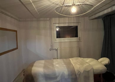 Cozy massage room at RST with Kallie in Andolsheim, Grand Est, FR featuring a warm ambiance and inviting bed.