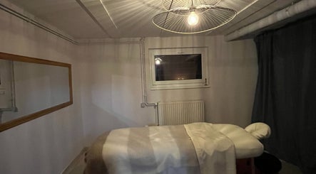 Cozy massage room at RST with Kallie in Andolsheim, Grand Est, FR featuring a warm ambiance and inviting bed.