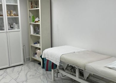 Treatment room at Medispa Naturhouse, Stevenage, England, GB with a massage bed and product shelves.