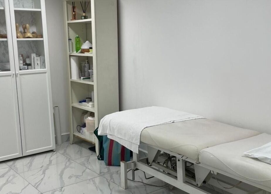 Tranquil treatment room at Medispa Naturhouse in Stevenage, England, GB, showcasing a massage table and beauty products.