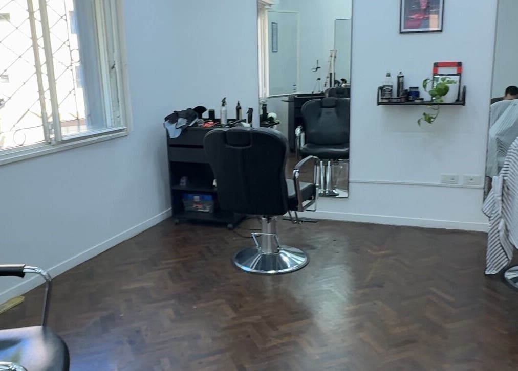 Interior de salón de belleza en Ottati Studio, Buenos Aires, con sillas y espejo minimalista.
