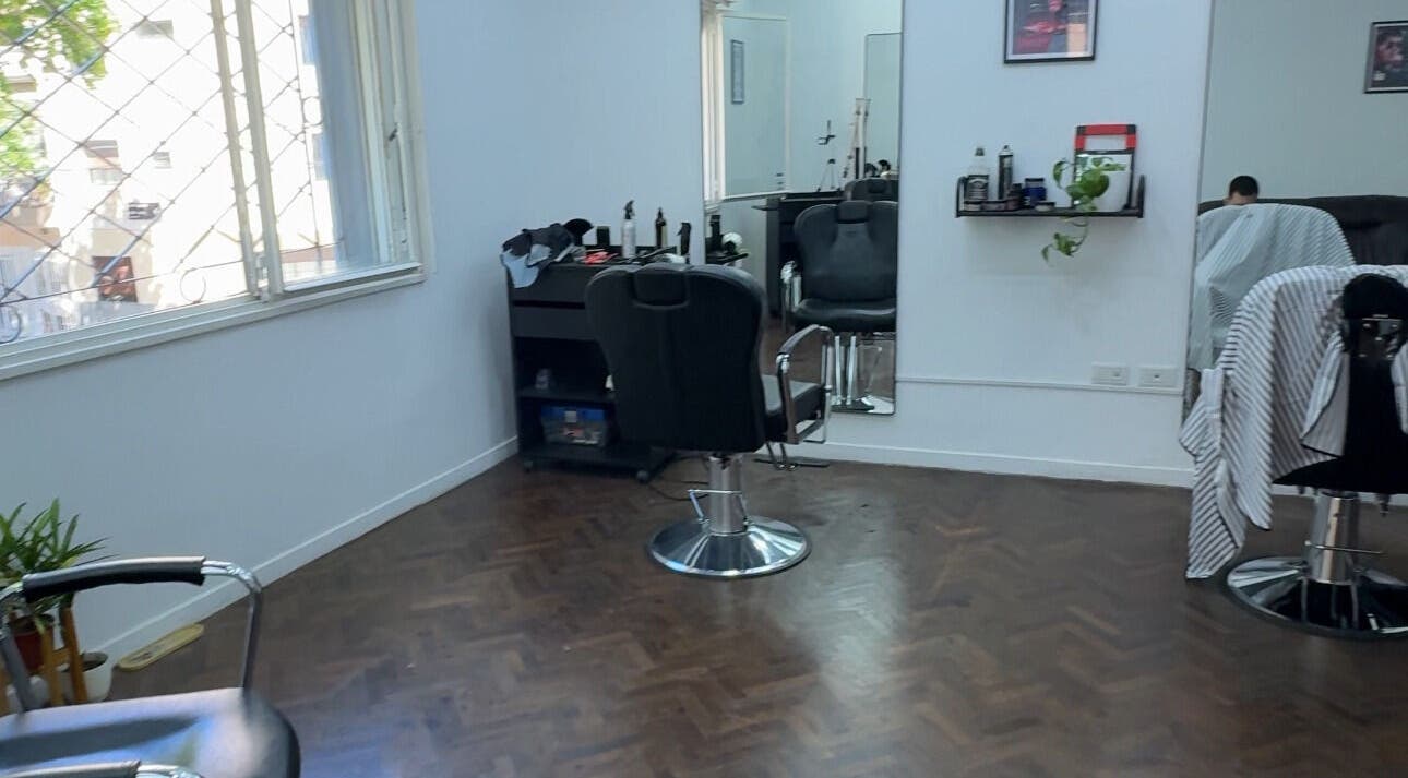 Interior de salón de belleza en Ottati Studio, Buenos Aires, con sillas y espejo minimalista.