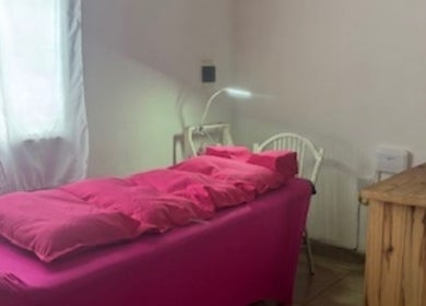 Inviting treatment room at MD Lashes, Concordia, Entre Ríos, AR, featuring a pink treatment bed and bright window.
