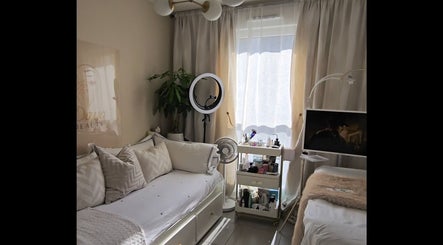 Espace de détente chez Daya Beauty à Cannes, Provence-Alpes-Côte d'Azur, FR, avec canapé et produits de beauté.