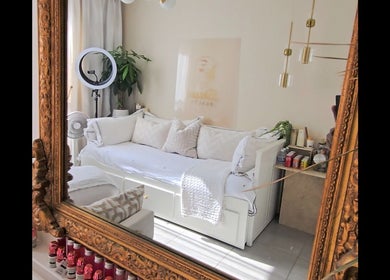 Intérieur élégant de Daya Beauty, Cannes, Provence-alpes-côte D'azur, FR, avec canapé blanc et miroir doré.