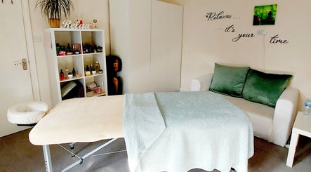 Relaxing treatment room at Harmony Wellbeing, Croydon, England, GB with a massage table and cozy decor.