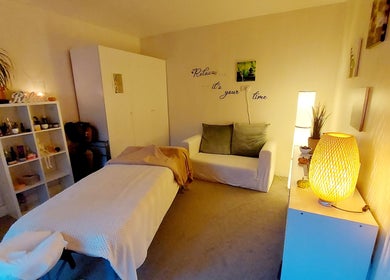 A tranquil massage room in Harmony Wellbeing, Croydon, England, GB, with warm lighting and soothing decor.