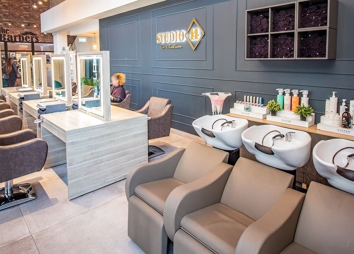 Modern salon interior at Studio 44 Clinic, featuring styling stations and wash basins in Gibraltar, GI.