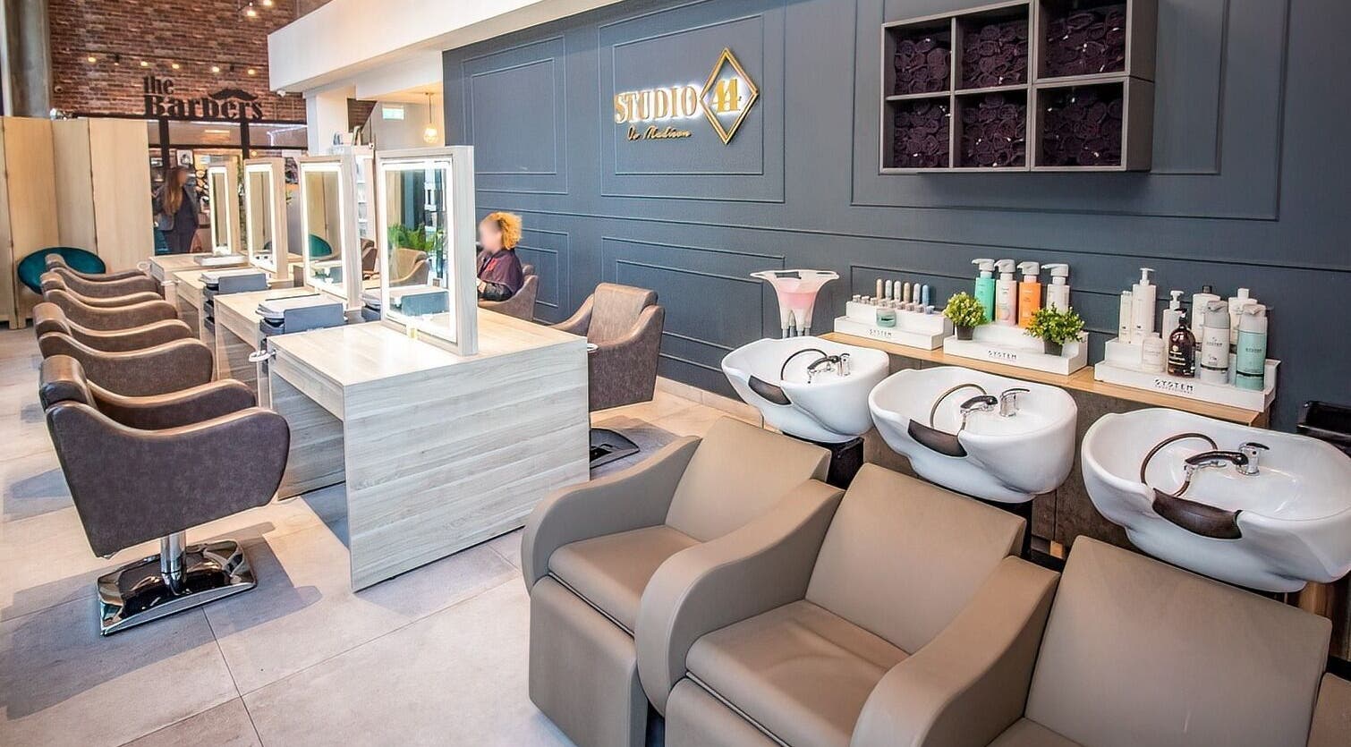 Modern salon interior at Studio 44 Clinic, featuring styling stations and wash basins in Gibraltar, GI.