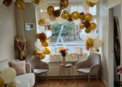 Elegant waiting area at Hair by Jess Marie, Great Sankey, England, GB with festive balloons and chic decor.