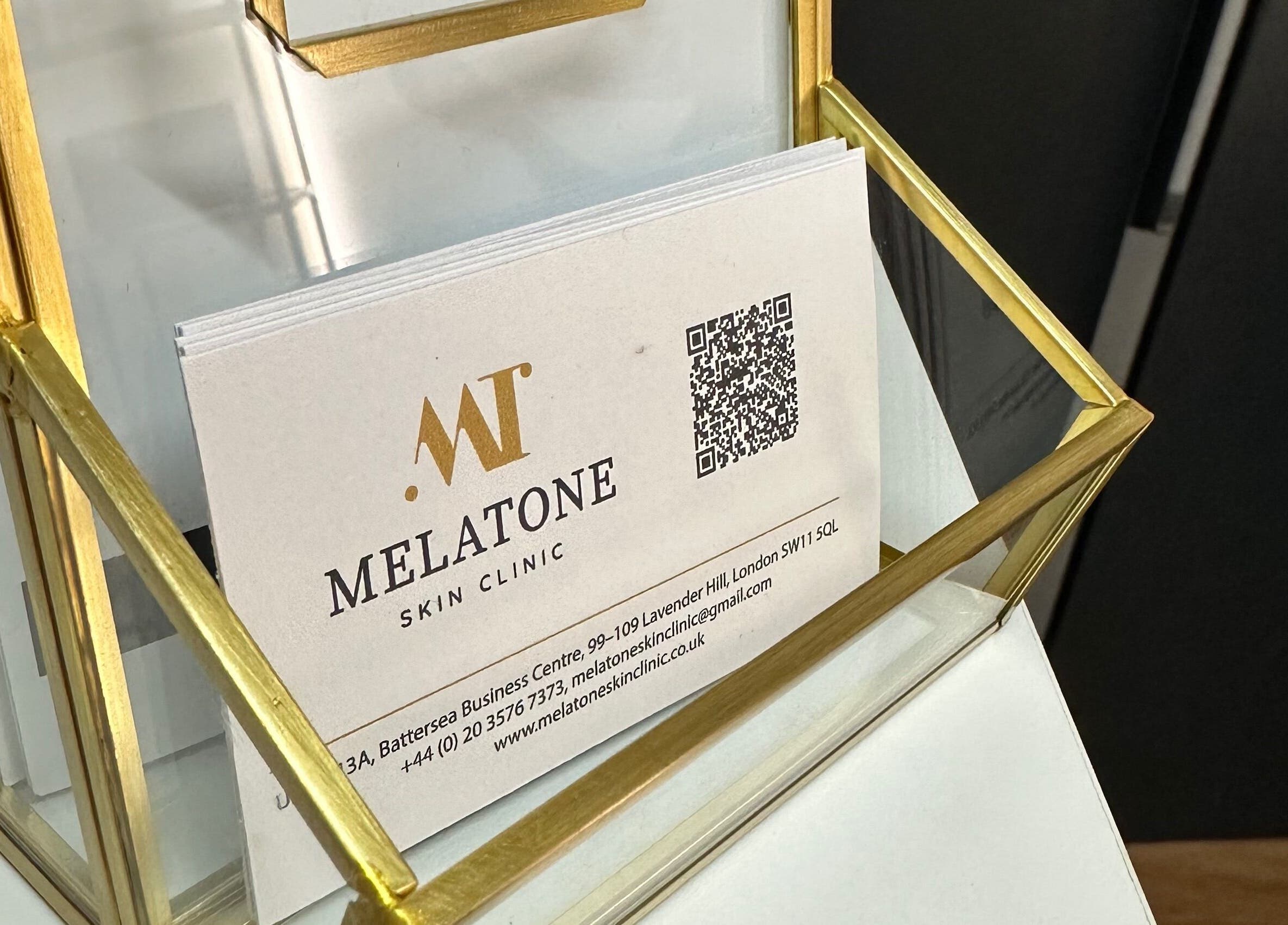 Elegant Melatone Skin Clinic business cards in a gold holder, London, England, GB.