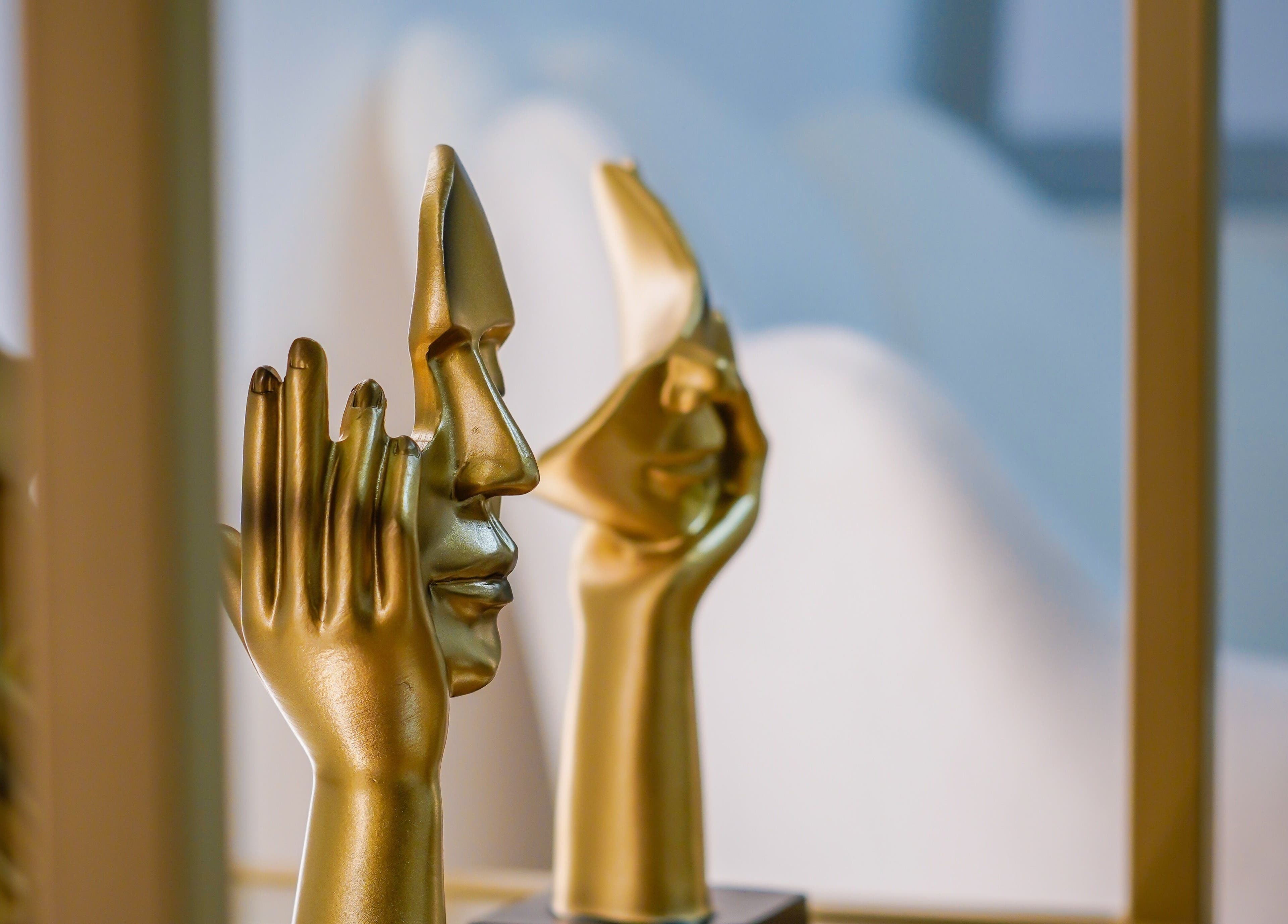 Artistic golden face sculptures at Melatone Skin Clinic, London, England, GB. Enhance your visit with artistic flair.