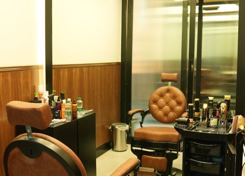 Sleek barber room at Noble Gents, Riyadh, Riyadh Province, SA, featuring plush chairs and grooming tools.