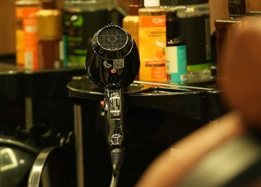 Hair salon tools at Noble Gents, Riyadh, Riyadh Province, SA, featuring a sleek dryer amid grooming products.