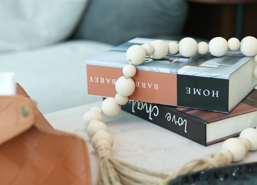 Chic decor at Noble Gents, Riyadh, featuring books and beads on a table.