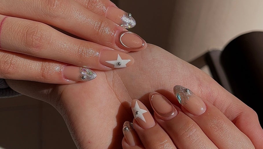 Artistic nail design with stars at Ju Nail Studio, Hermosillo, Sonora, MX. Glitter and star accents featured.