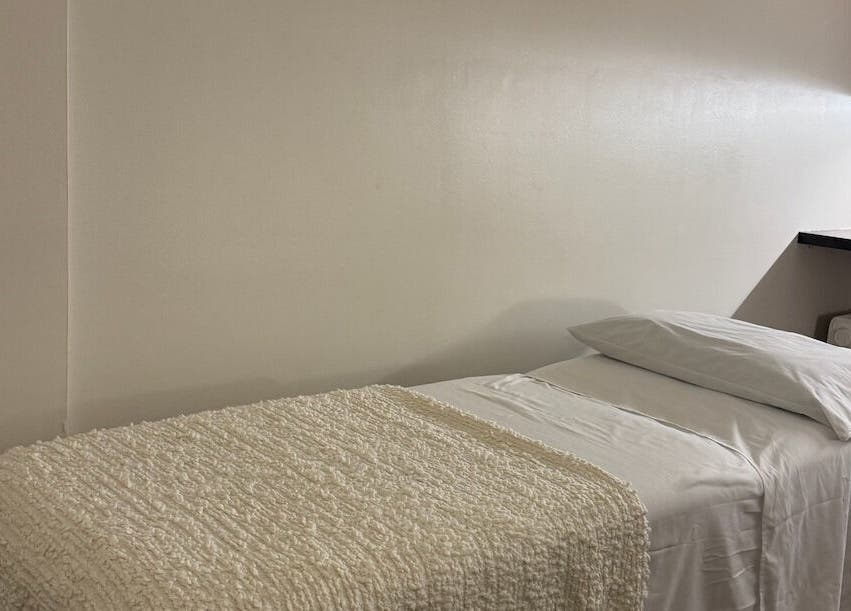 Cozy massage room at Contourista London in London, England, GB with a softly lit bed and warm decor.