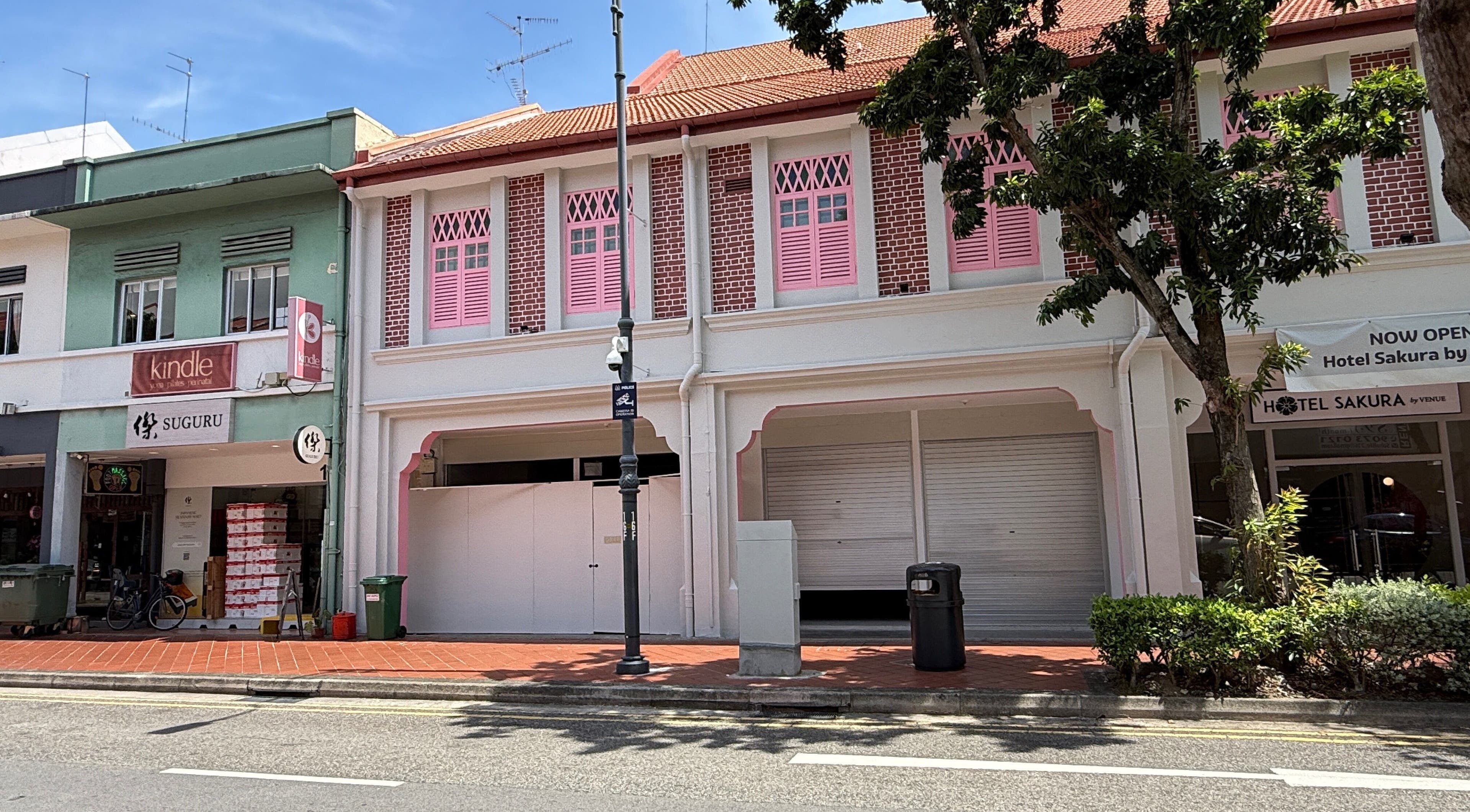 Street view of The Fade House in Singapore, SG, showcasing its vibrant, traditional architecture.