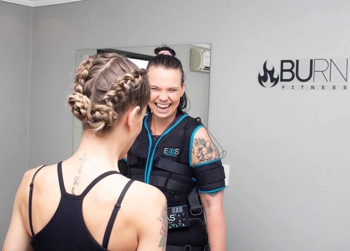 Clients laughing during EMS training at Burn Studio in Gqeberha, Eastern Cape, ZA.