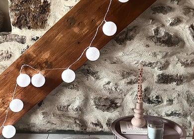 Éclat d’âme: bien-être à Vinezac, déco chaleureuse avec guirlande lumineuse et bougies.