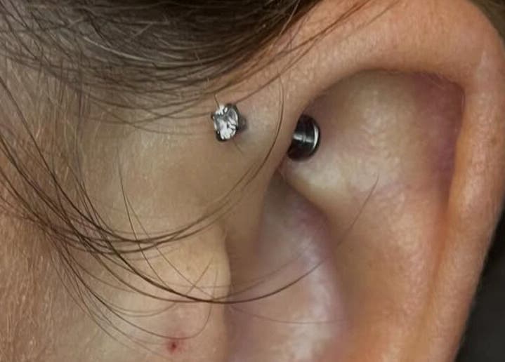 Close-up of an ear piercing with a shiny stud at KB Piercings & Pearly Whites, Garforth, England, GB.