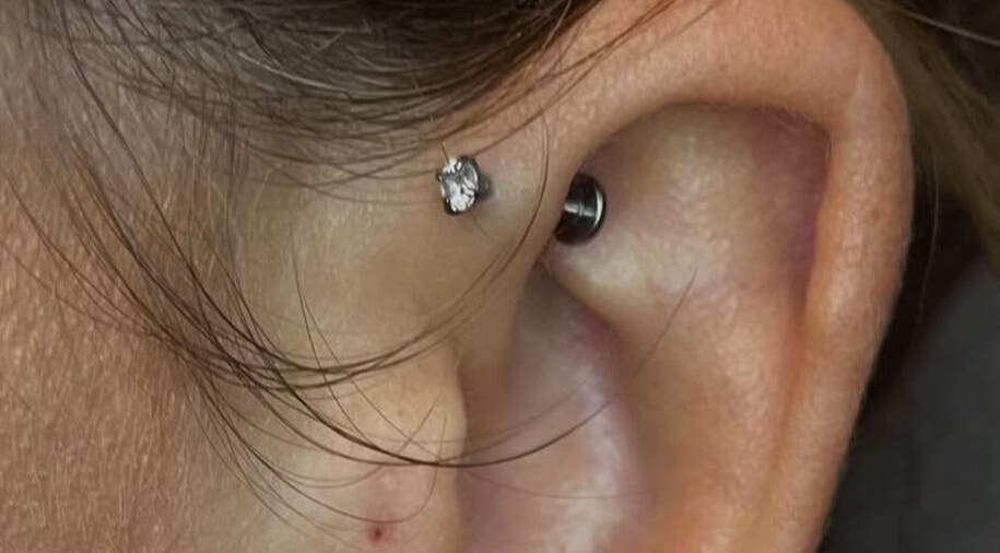 Close-up of an ear piercing with a shiny stud at KB Piercings & Pearly Whites, Garforth, England, GB.