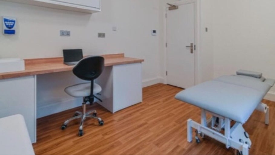 Modern therapy room at The Universal Energy Consultant, London, England, GB with treatment bed and desk.