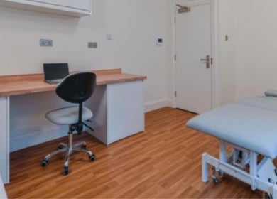 Modern therapy room at The Universal Energy Consultant, London, England, GB with treatment bed and desk.