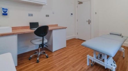 Modern therapy room at The Universal Energy Consultant, London, England, GB with treatment bed and desk.