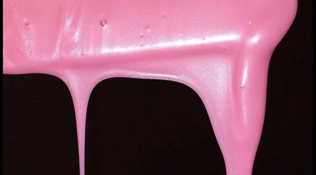 Vibrant pink nail polish dripping at Ambitious Beauty Bar in Virginia, Virginia, US, creating a striking visual.