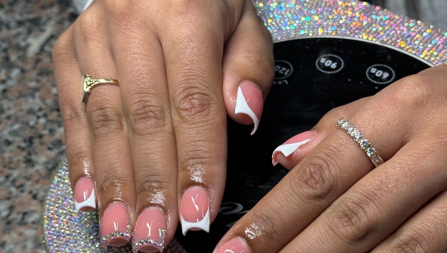 Elegant nail art at Ambitious Beauty Bar in Virginia, Virginia, US. Stylish pink and white manicure with rhinestones.