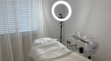 Cozy treatment room at SknandSculpt, Ely, England, GB, featuring a plush bed and skincare equipment.